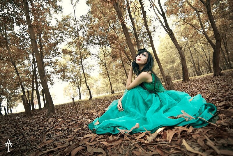 Woman in green dress in autumn forest