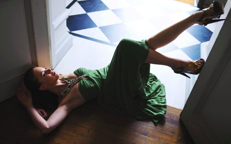 Woman in green dress lying on floor