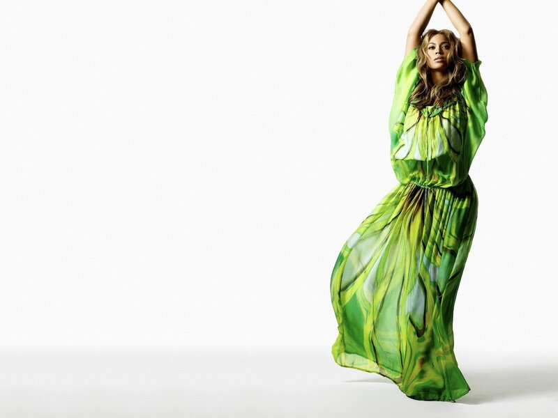 woman in green dress with arms raised
