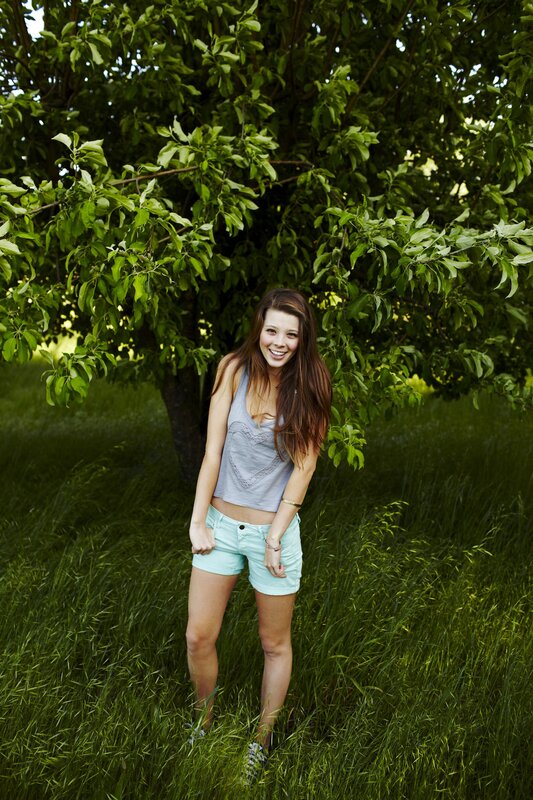 woman in green field smiling