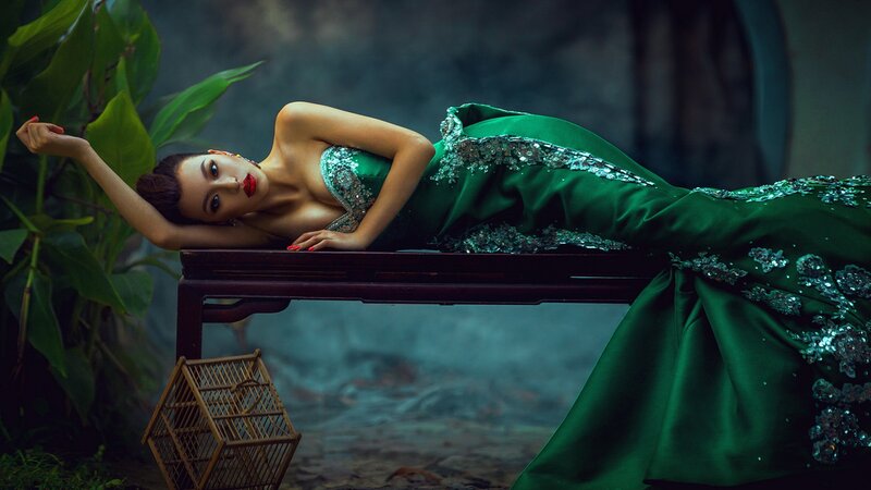 Woman in green gown on bench