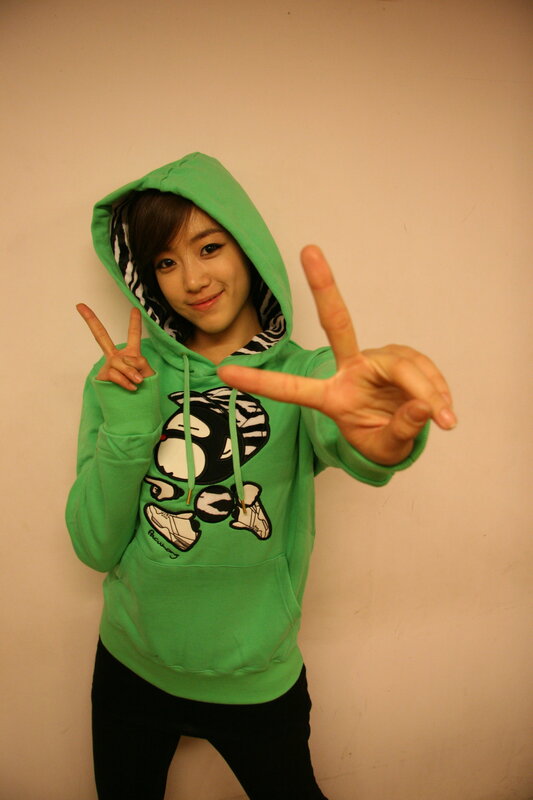 woman in green hoodie making peace signs