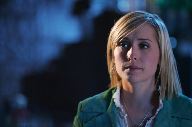 woman in green jacket looking concerned
