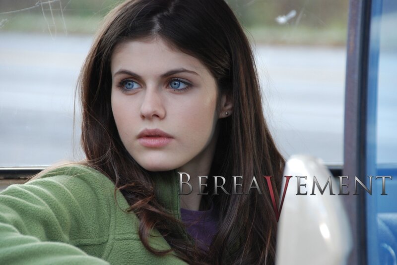 woman in green jacket looking out window