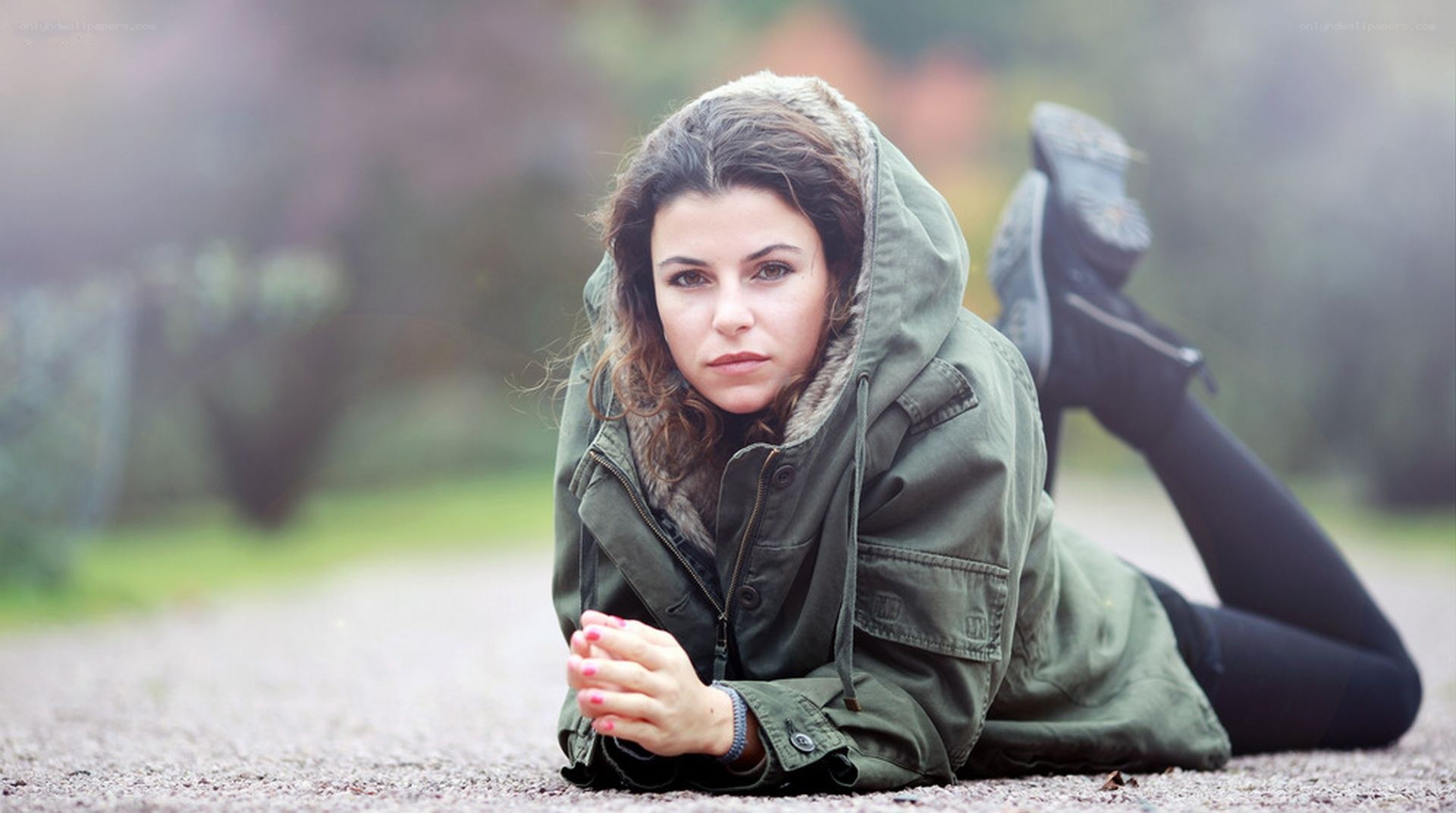 woman in green jacket lying down