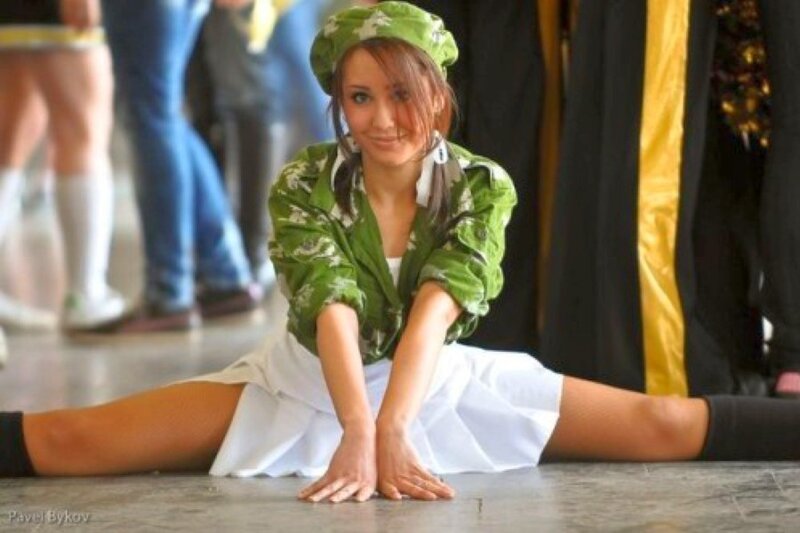 Woman in green outfit doing split