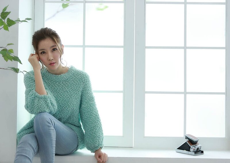 woman in green sweater by window
