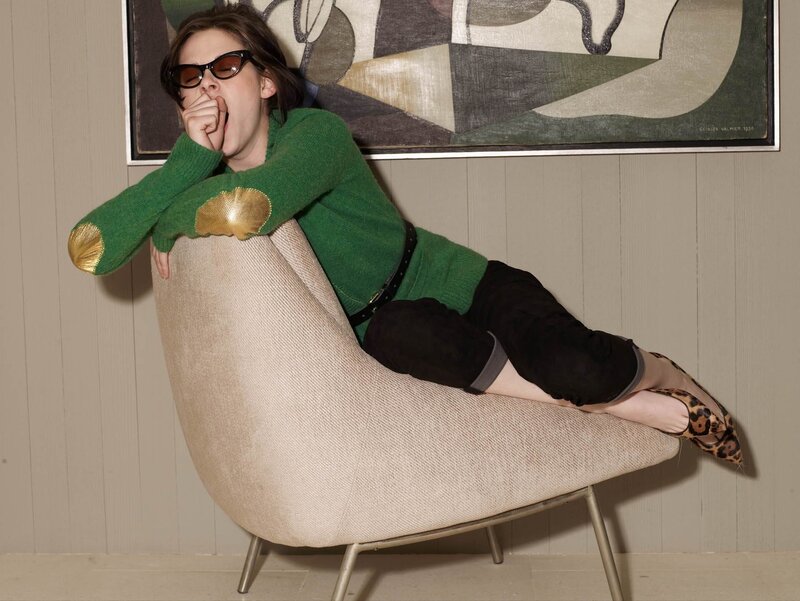 Woman in green sweater on chair