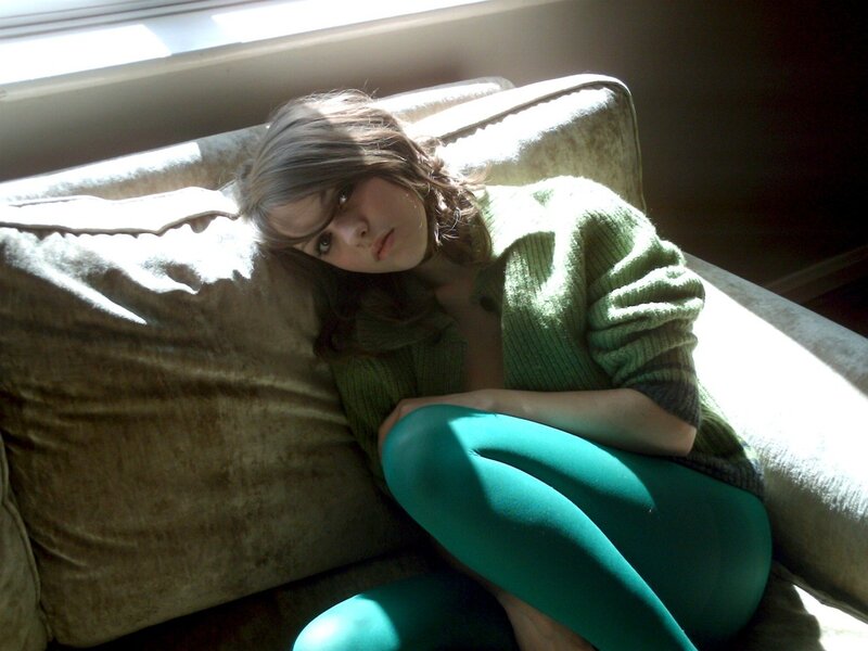 woman in green sweater on couch