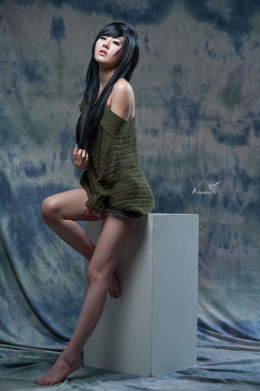 woman in green sweater sitting on block