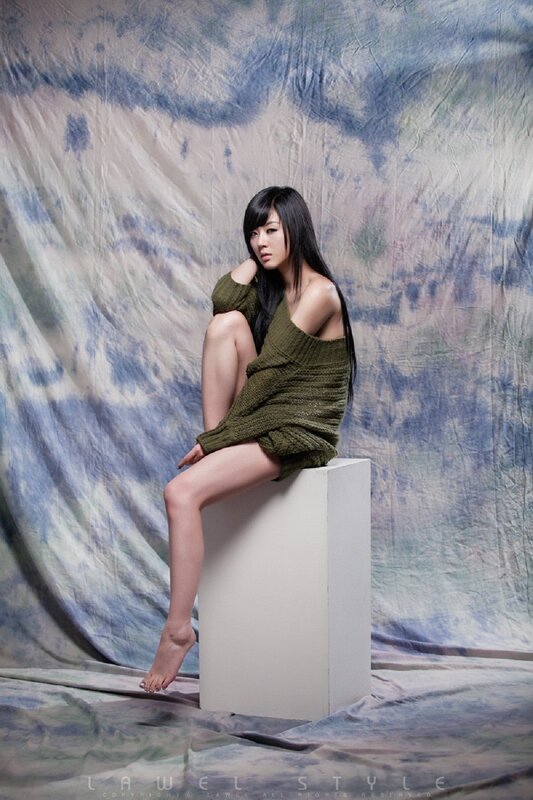 woman in green sweater sitting on block