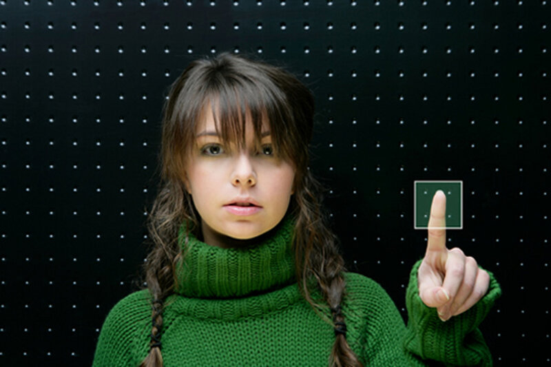 woman in green sweater touching screen