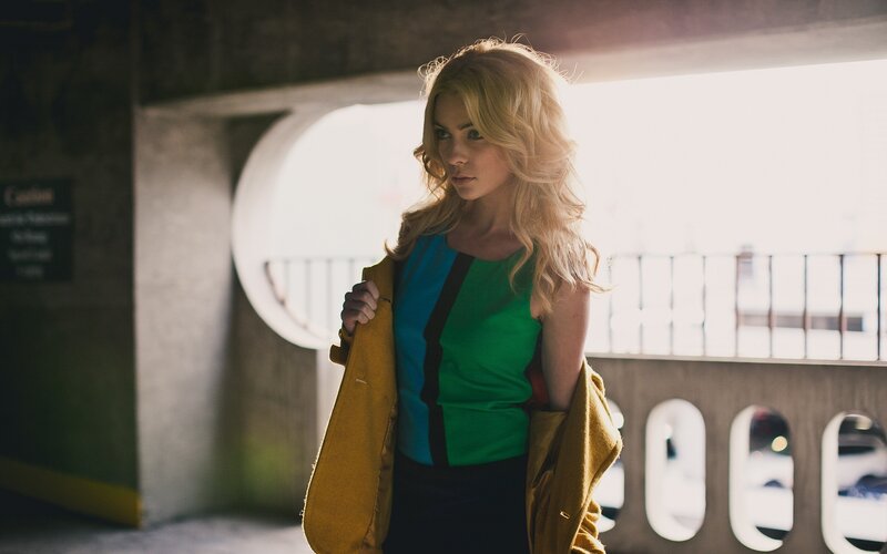 woman in green top holding coat
