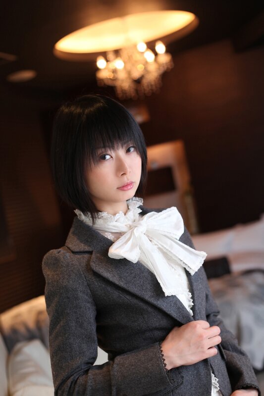 woman in grey coat with white bow