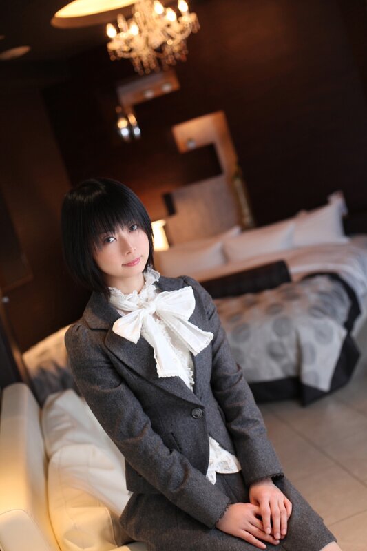 woman in grey suit with bow