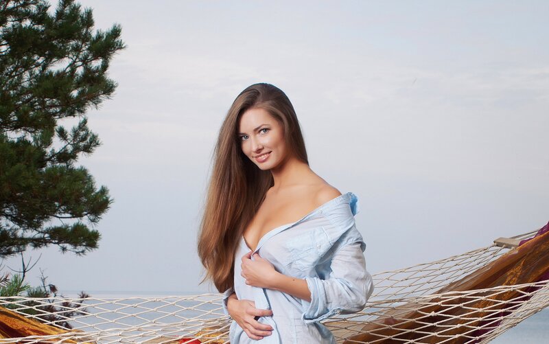 Woman in hammock by the sea