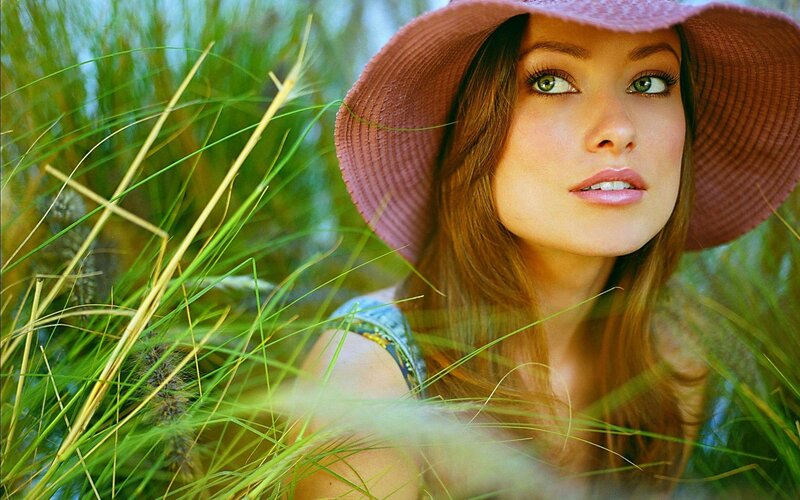 woman in hat among tall grass