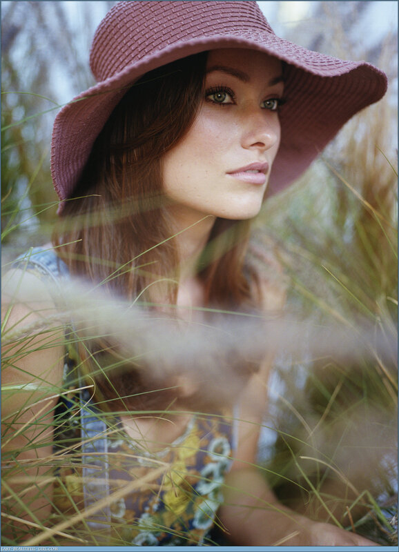 woman in hat among tall grass