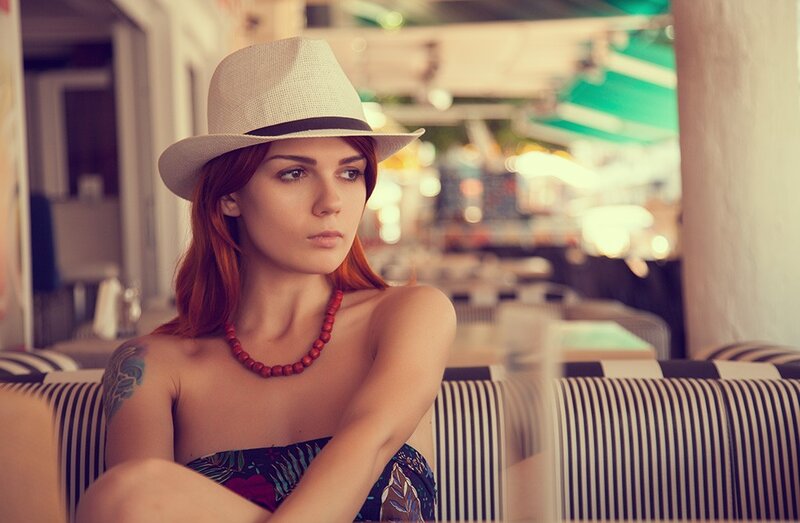 Woman in hat at outdoor cafe