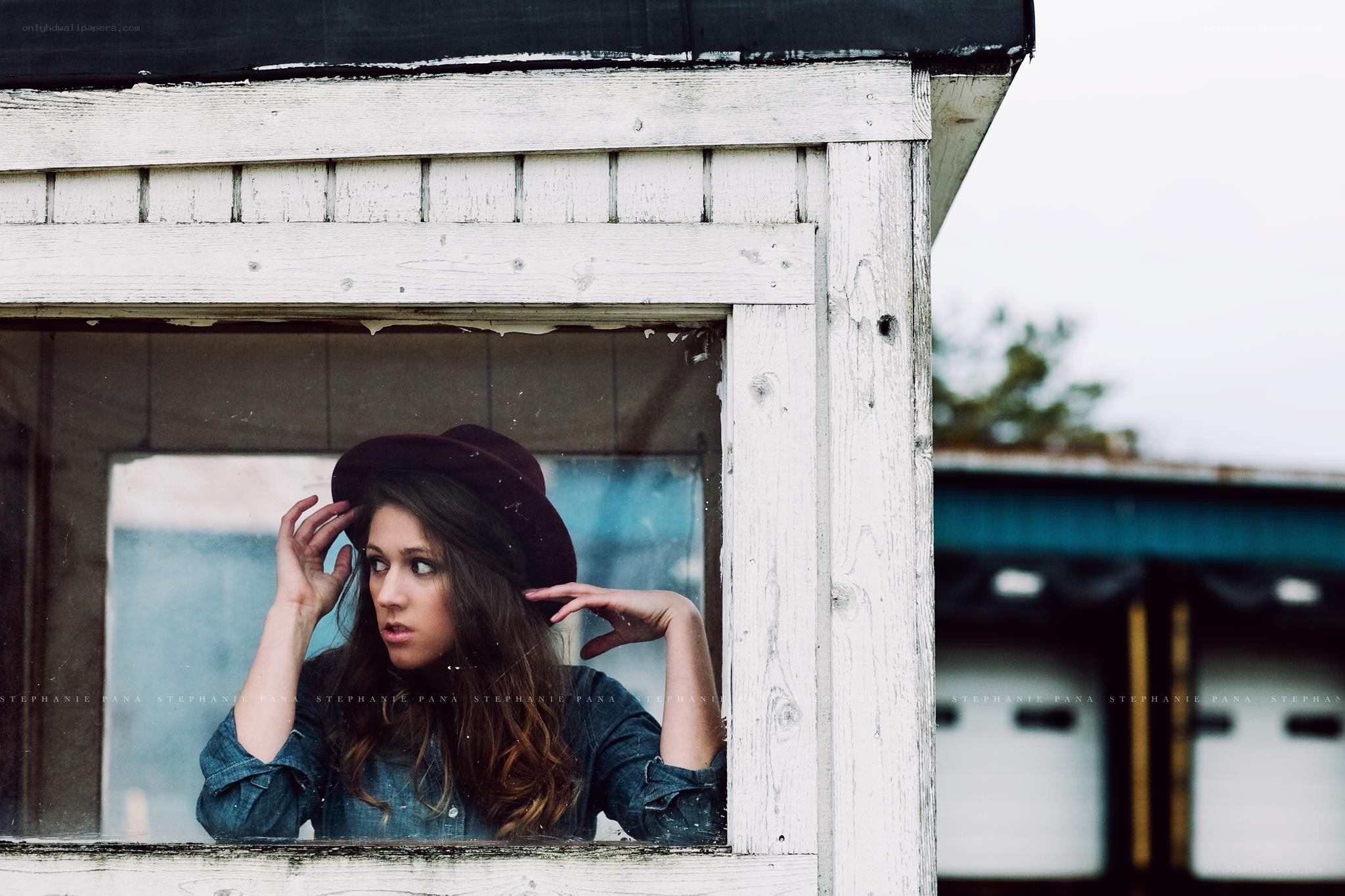 woman in hat at window