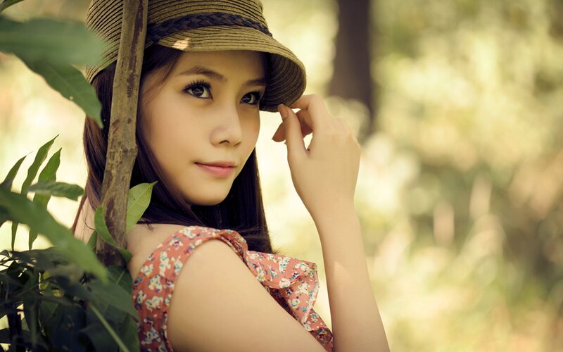 woman in hat by foliage
