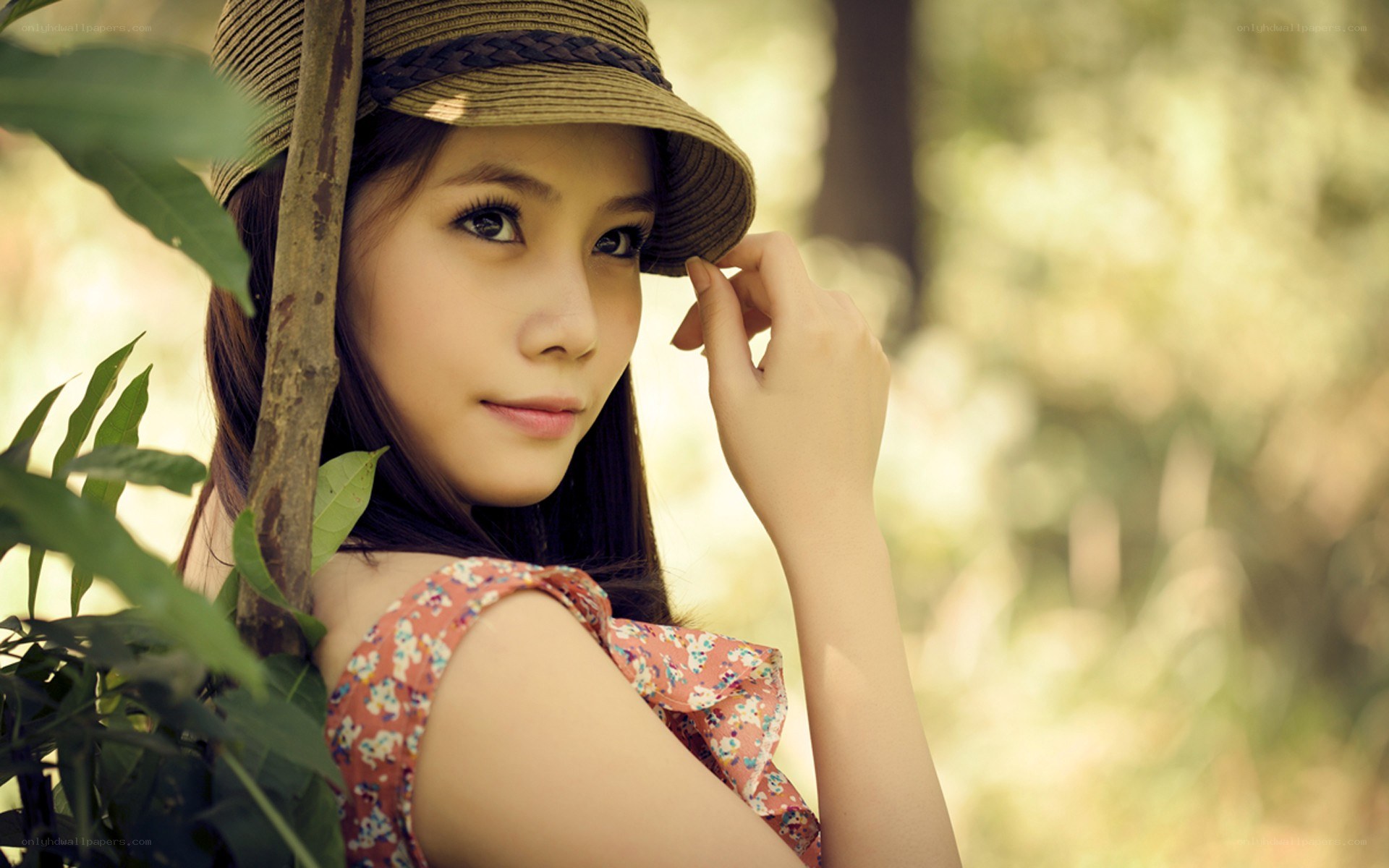 woman in hat by foliage
