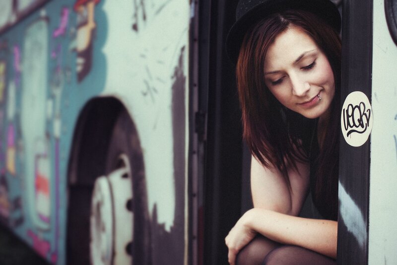 woman in hat by graffiti bus