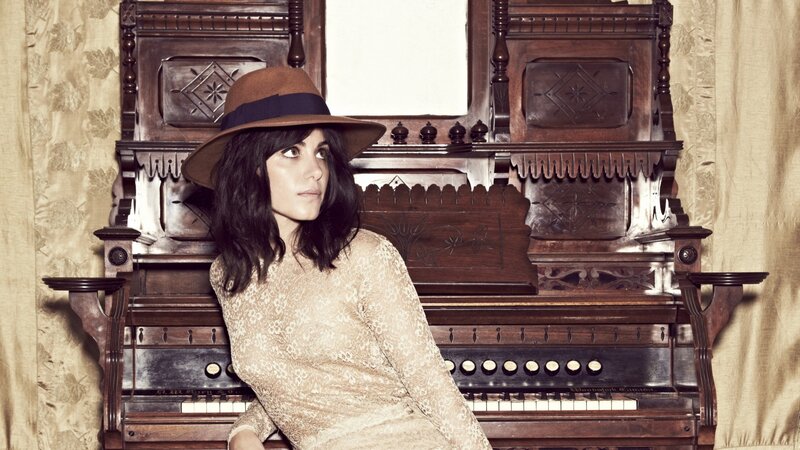 woman in hat by piano