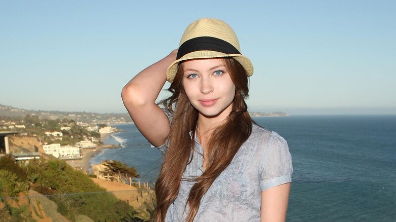 woman in hat by the ocean