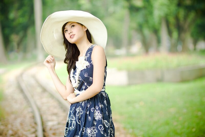 Woman in hat by train tracks