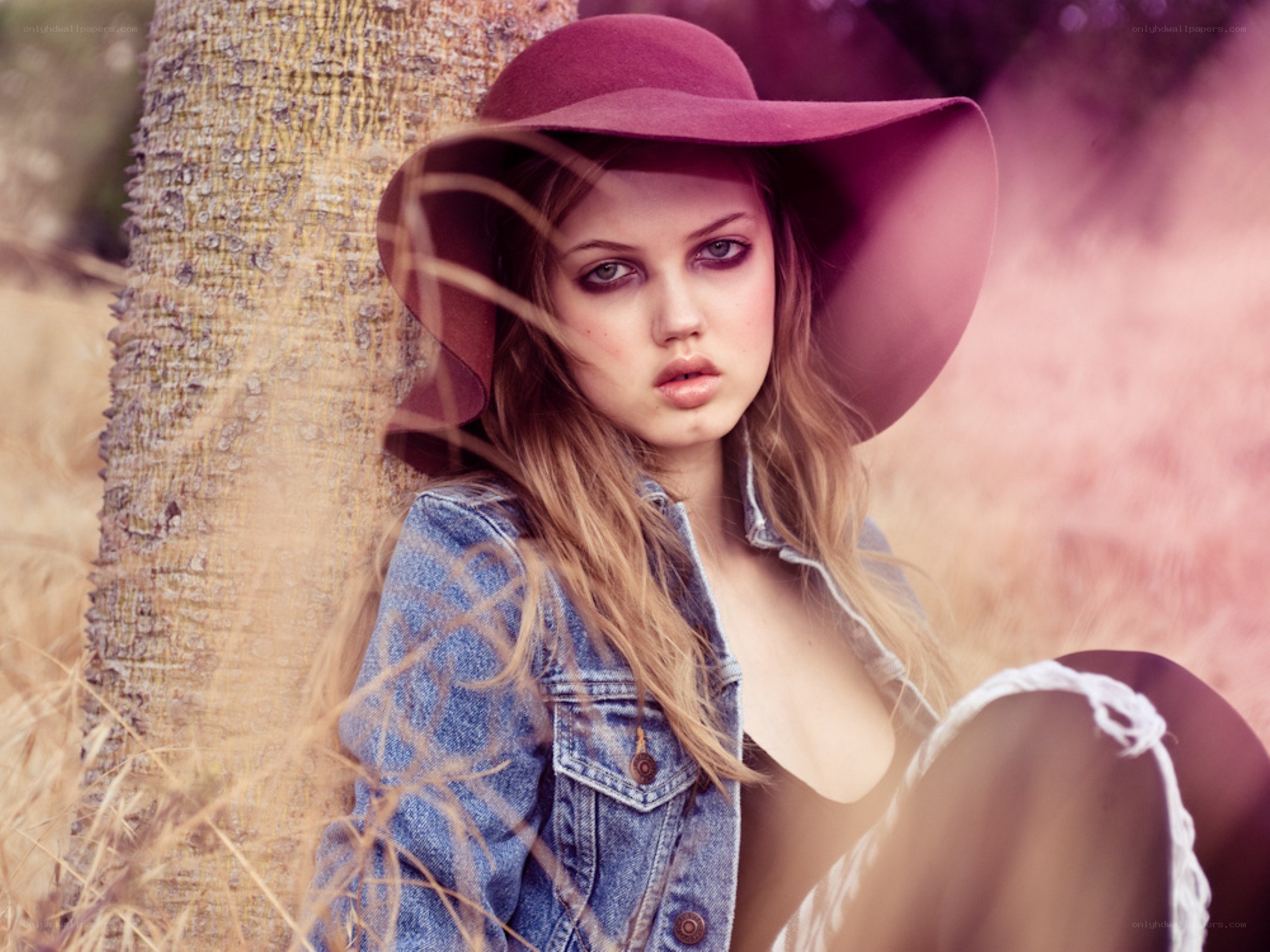 Woman in hat by tree