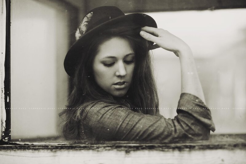woman in hat by window