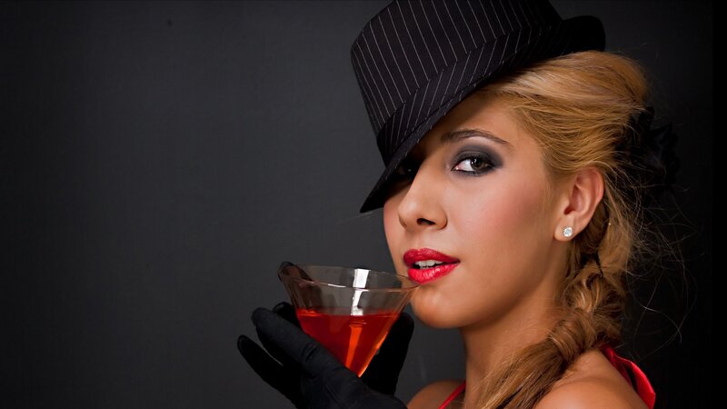 woman in hat holding cocktail