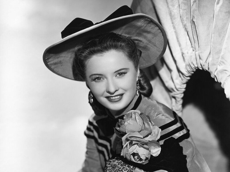 Woman in Hat Holding Flower