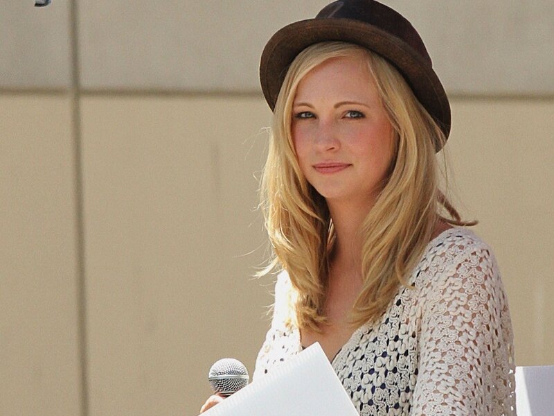 Woman in hat holding microphone