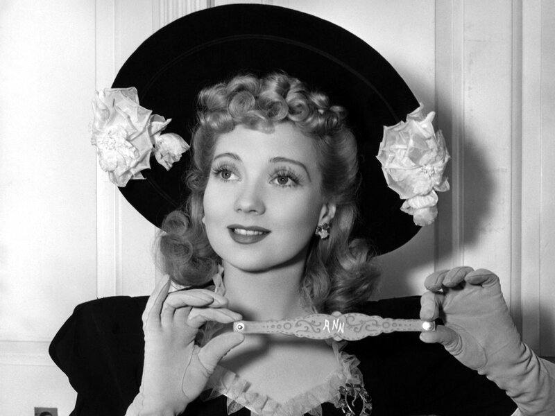Woman in Hat Holding Object