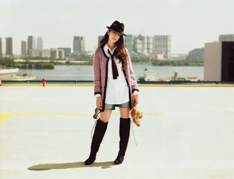 woman in hat holding teddy bear