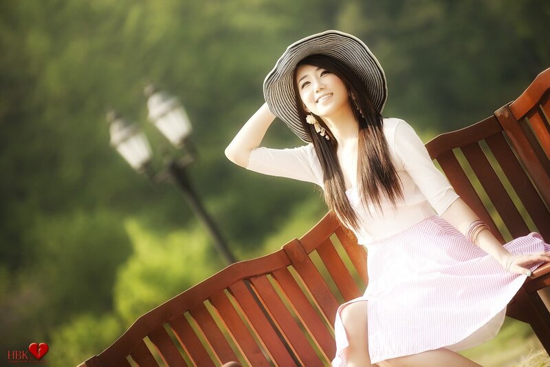 Woman in hat on park bench