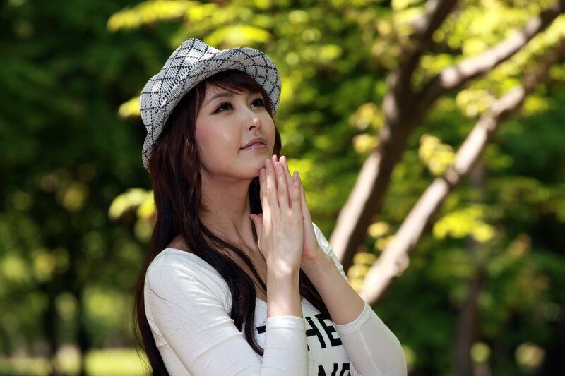 woman in hat praying outdoors