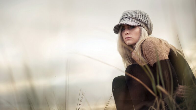 woman in hat sitting in grass