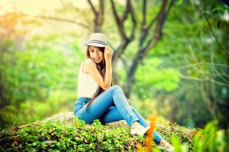Woman in hat sitting on a rock