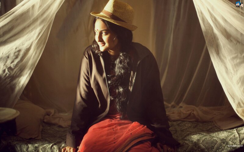 woman in hat sitting on bed