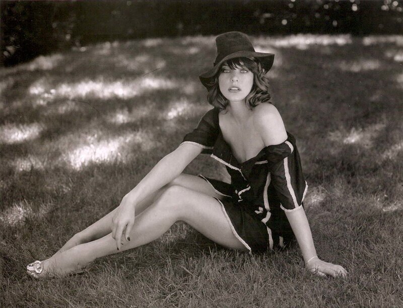 woman in hat sitting on grass