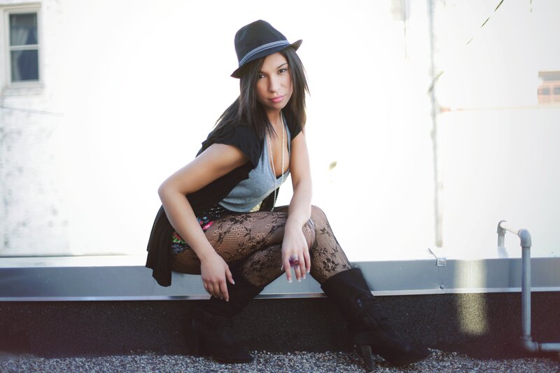 woman in hat sitting on ledge