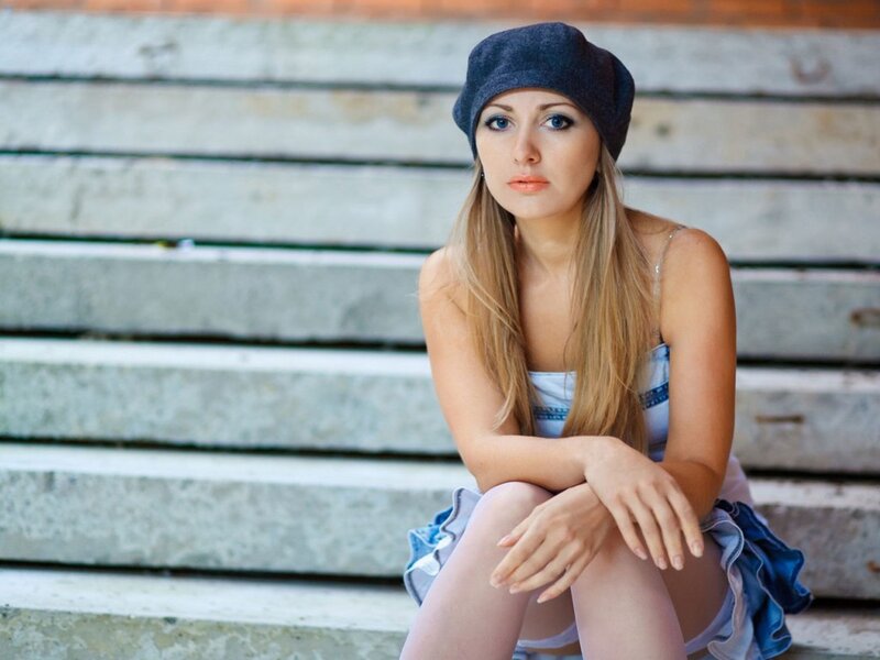woman in hat sitting on steps