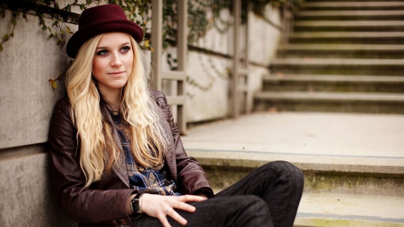 woman in hat sitting on steps