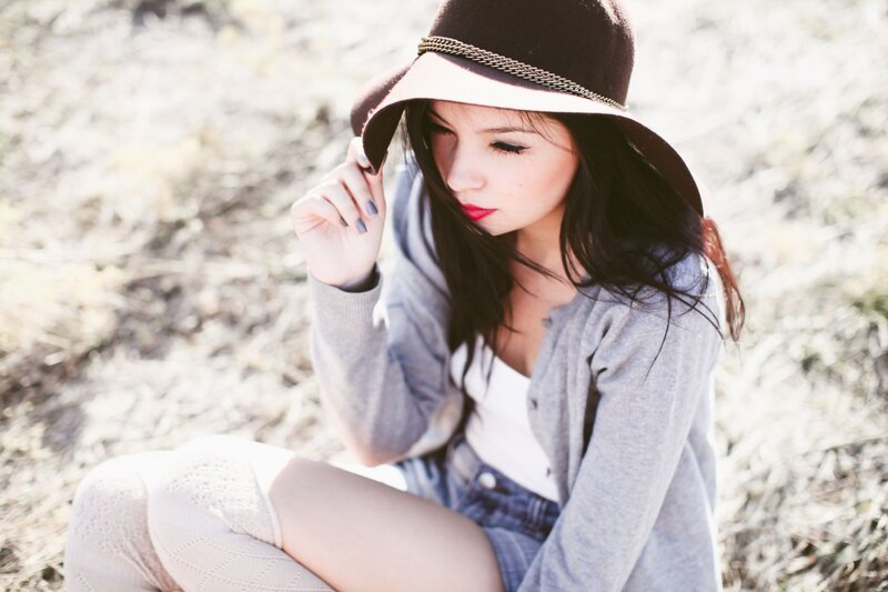 woman in hat sitting outdoors