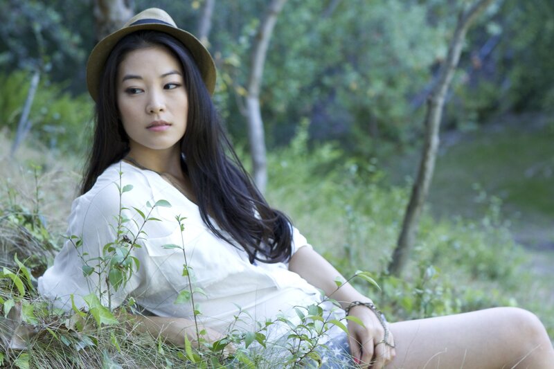 woman in hat sitting outdoors