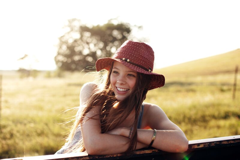 woman in hat smiling outdoors