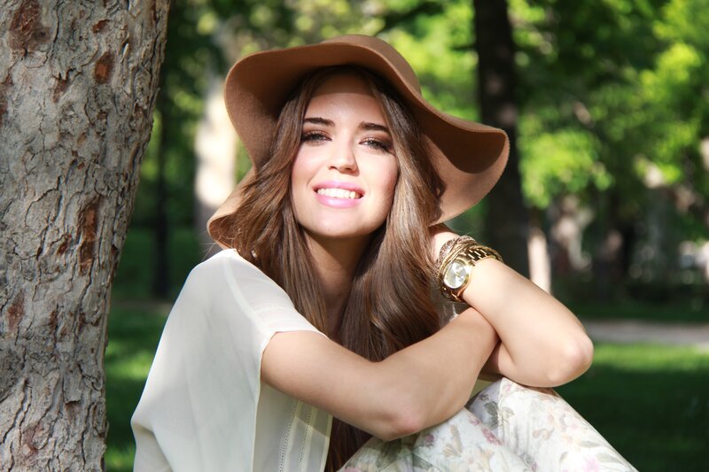 woman in hat smiling outdoors
